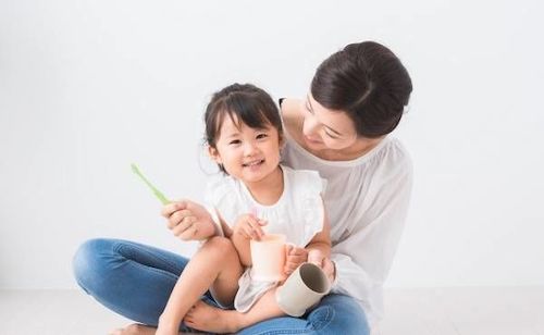 親子で仕上げ磨きをする様子