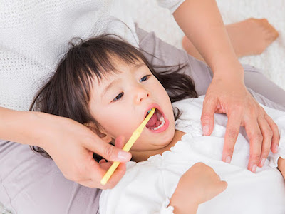 お子様のお口の中をチェックする様子